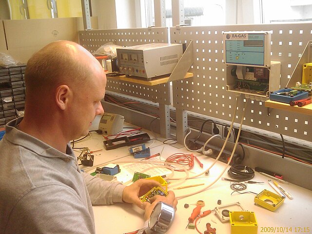 Werkskalibrierung S Mitarbeiter prüft einen geöffneten Gasmessfühler am Werkstattarbeitsplatz